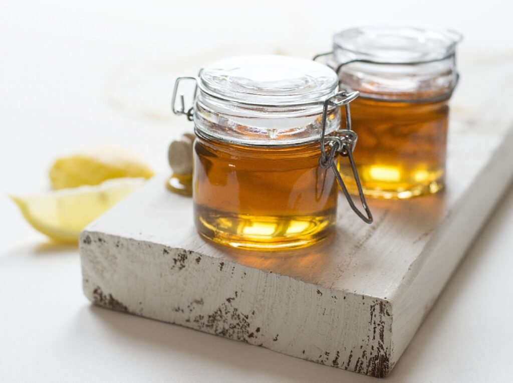 Two jars of honey next to each other on a kitchen board